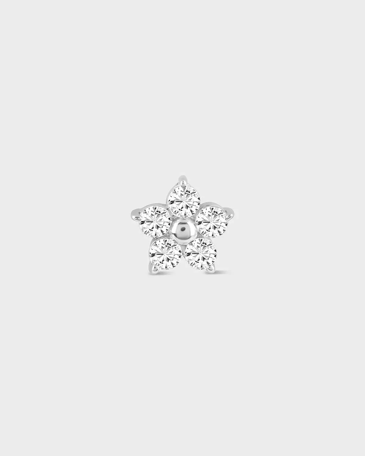 Flower shaped diamond earring on a light gray background