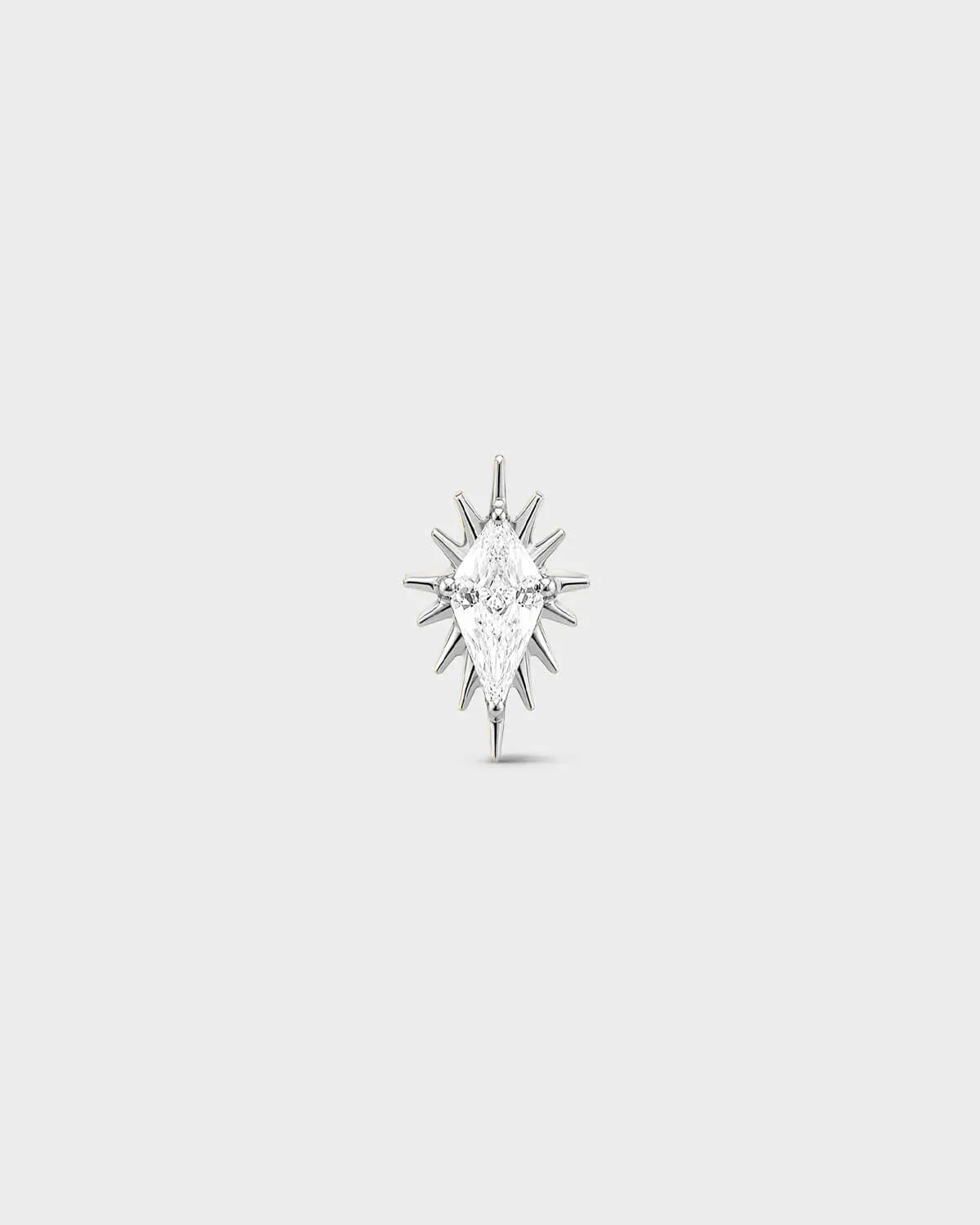 Polished silver titanium threadless end earring with a marquise-cut clear stone set within a sculpted starburst design. On a light grey background.