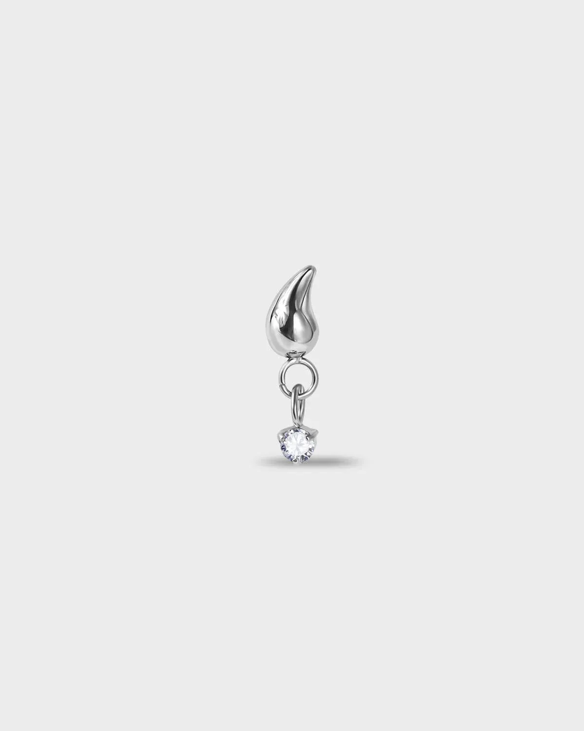 Polished silver titanium earring with a tear drop shape at the top and a suspended clear solitaire dangle on a light gray background