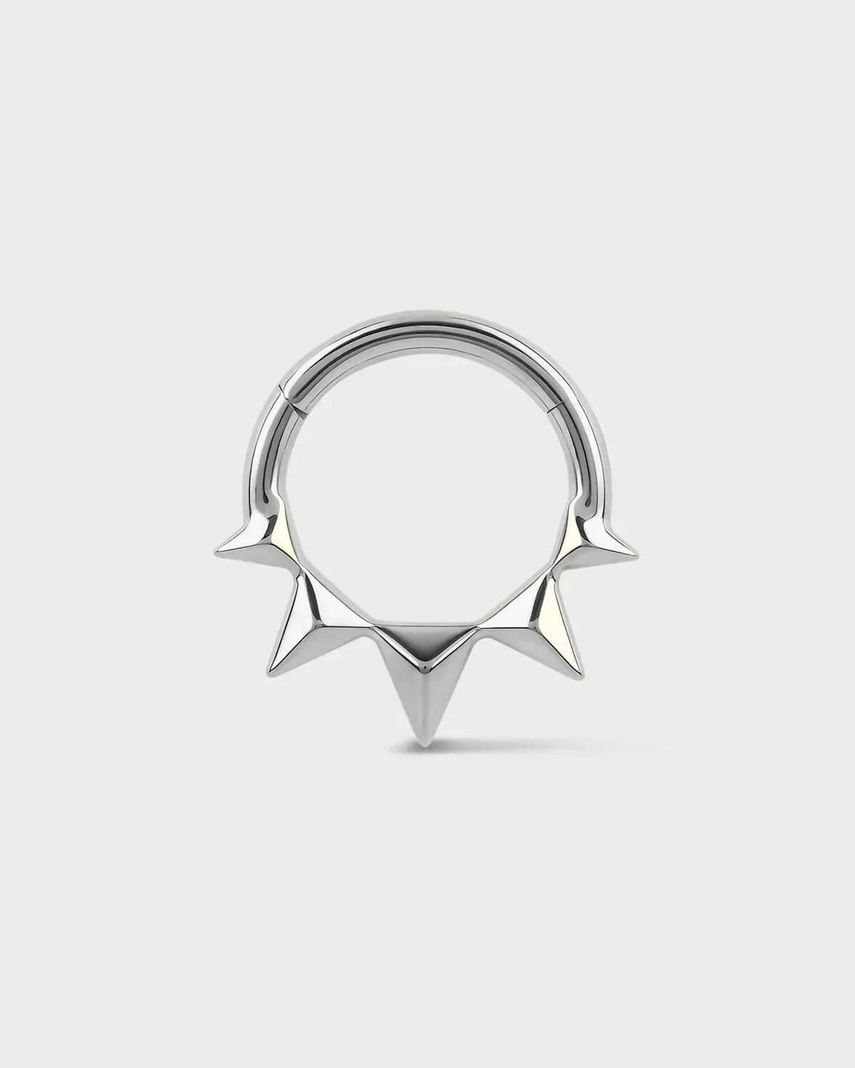 Silver septum ring with spike design on a white background