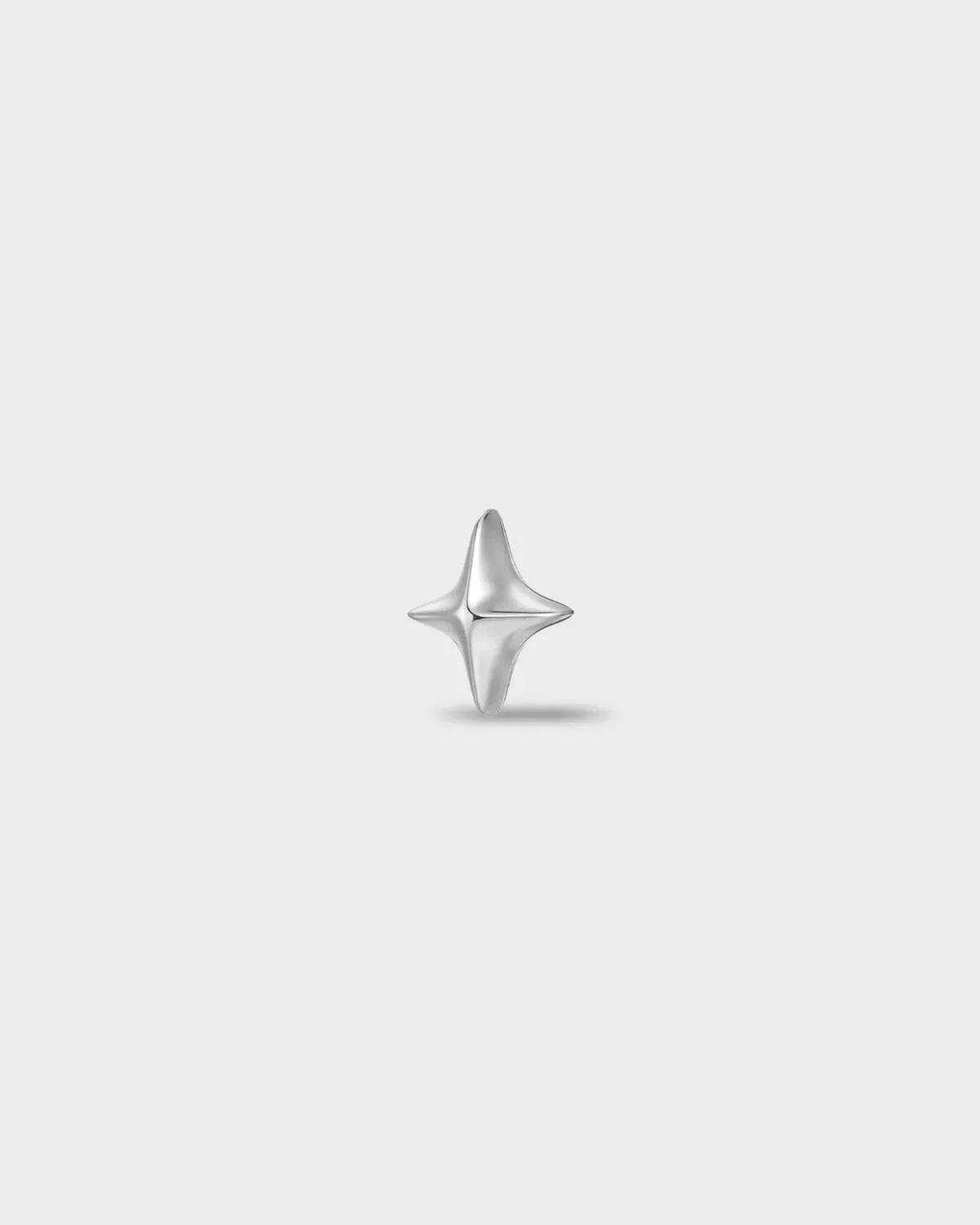 Polished titanium earring with a polished four-point star shape on a light gray background.