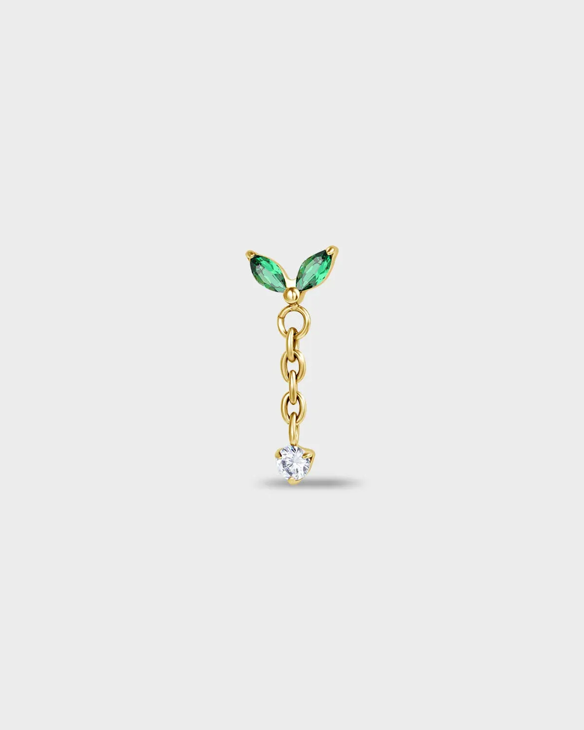 Gold titanium earring with two marquise-cut green stones and a short chain detail, finished with a clear round-cut gem on a light gray background.
