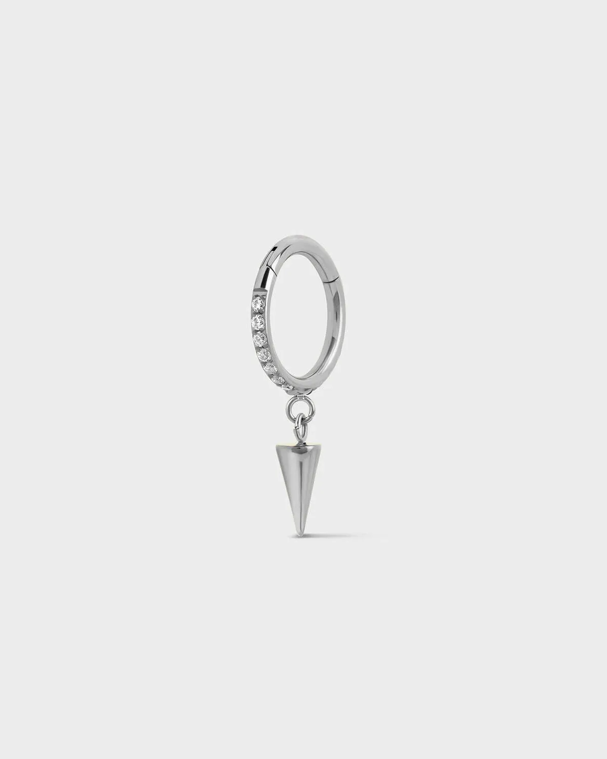 Polished silver titanium hinged ring with pave gems around the outer edge and a single cone dangle charm sat on a light gray background.