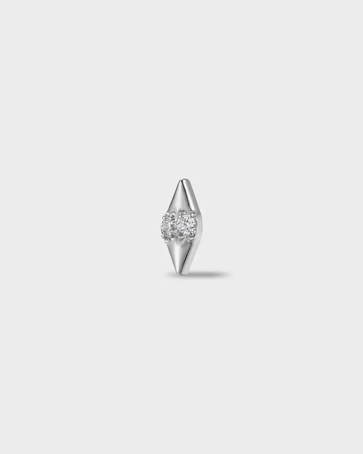 Polished titanium earring with two round-cut clear stones set into a smooth, tapered base, on a light gray background.