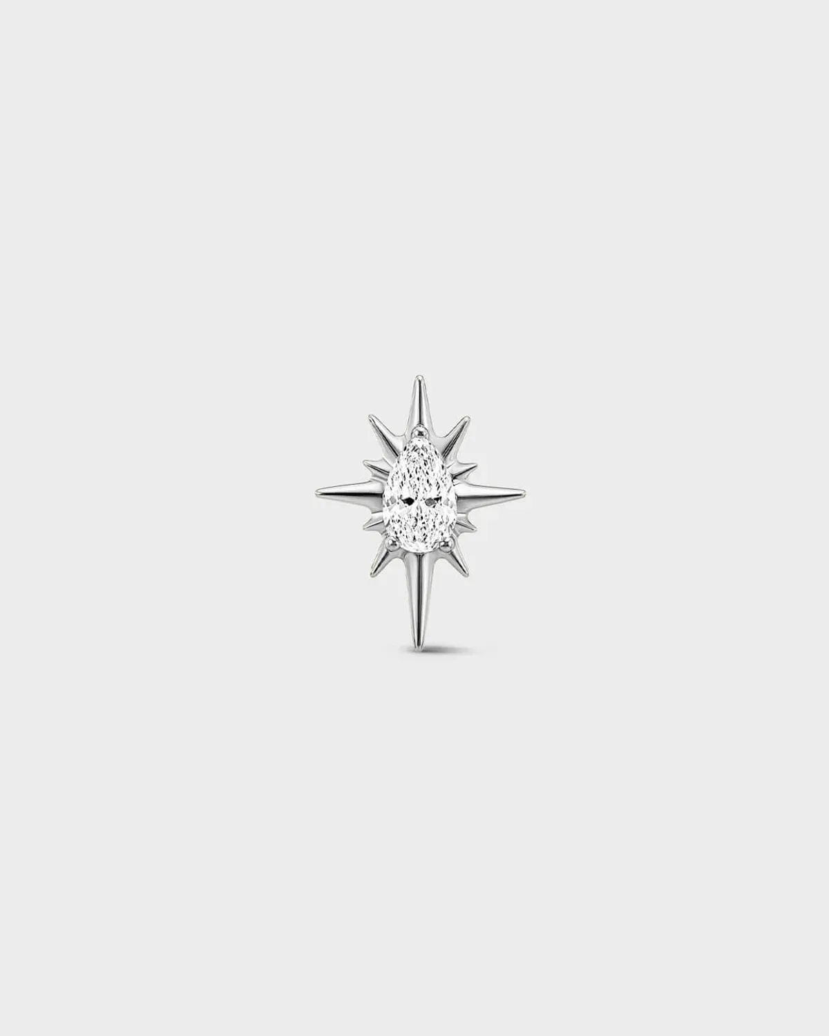 Polished silver titanium threadless end with a marquise-cut clear stone set within a sculpted starburst design. On a light grey background.