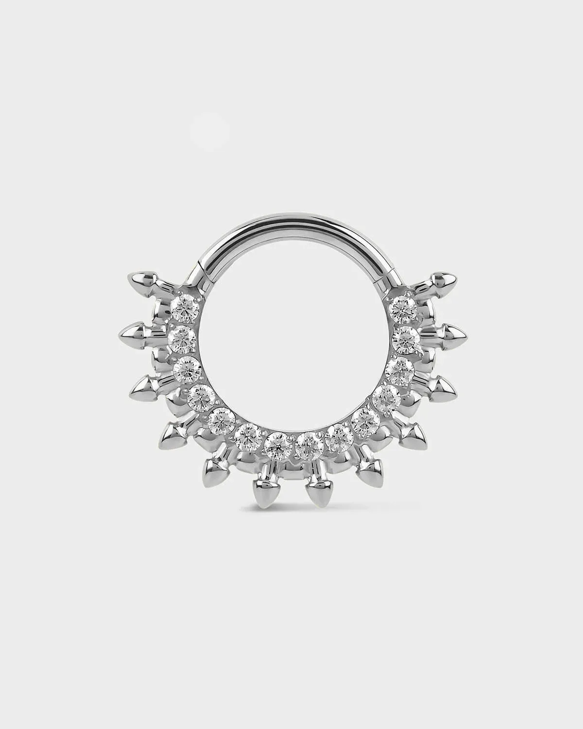 Polished titanium septum daith ring with diamond-like stones on a light gray background