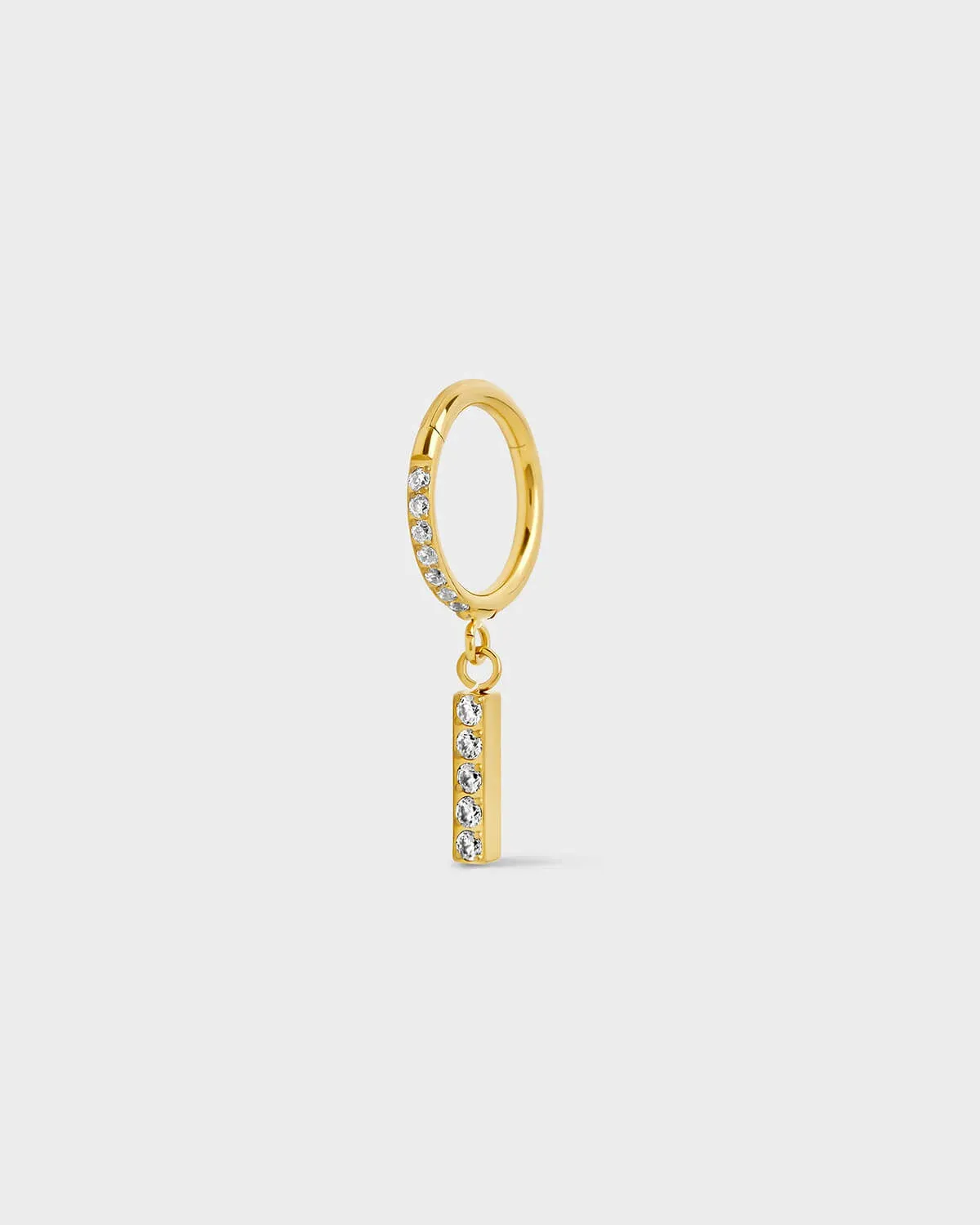 Gold titanium ring with pavé set gems along the front edge, finished with a vertical bar drop accented by a row of matching pavé stones. On a light gray background.