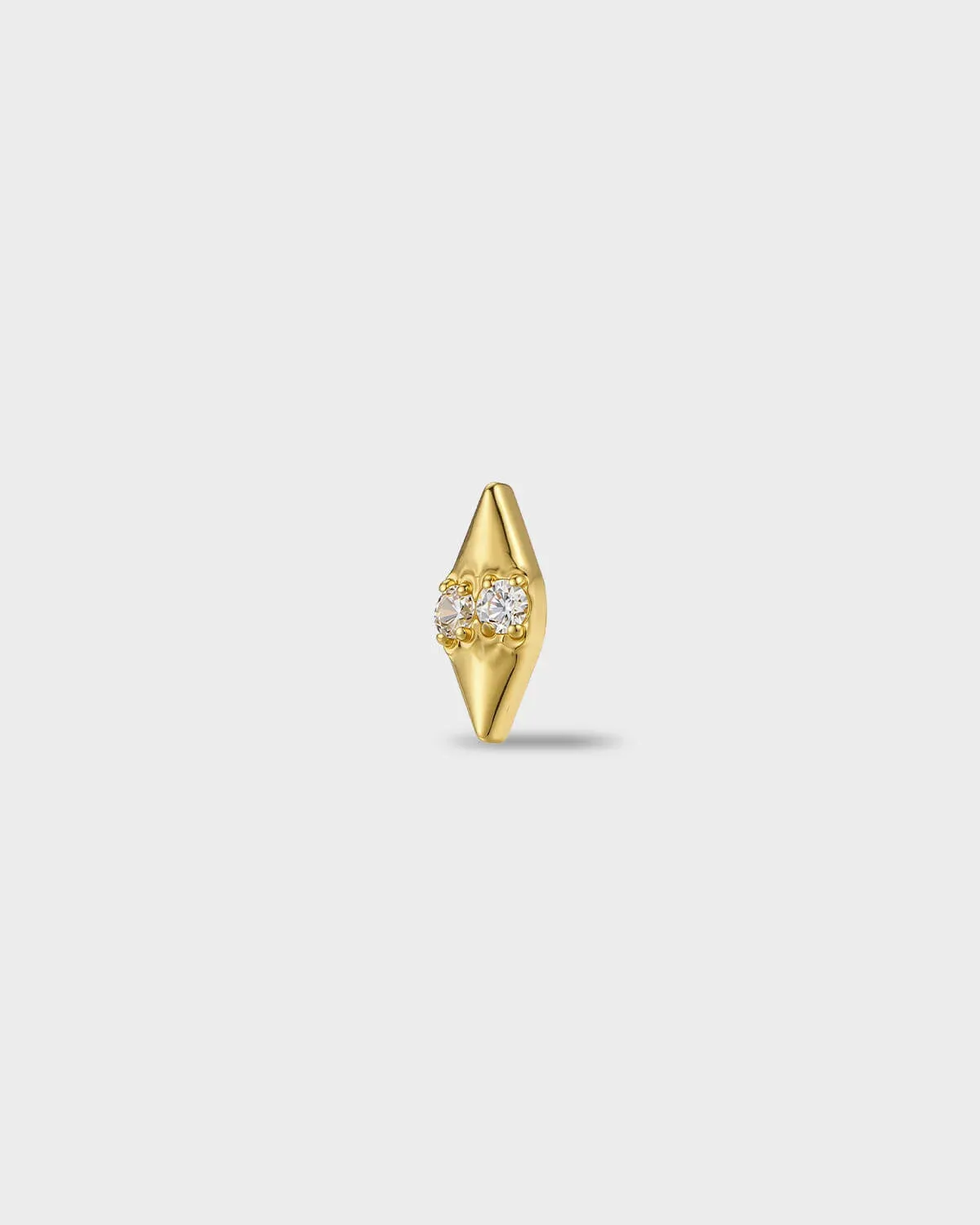 Gold titanium earring with two round-cut clear stones set into a smooth, tapered base, on a light gray background.