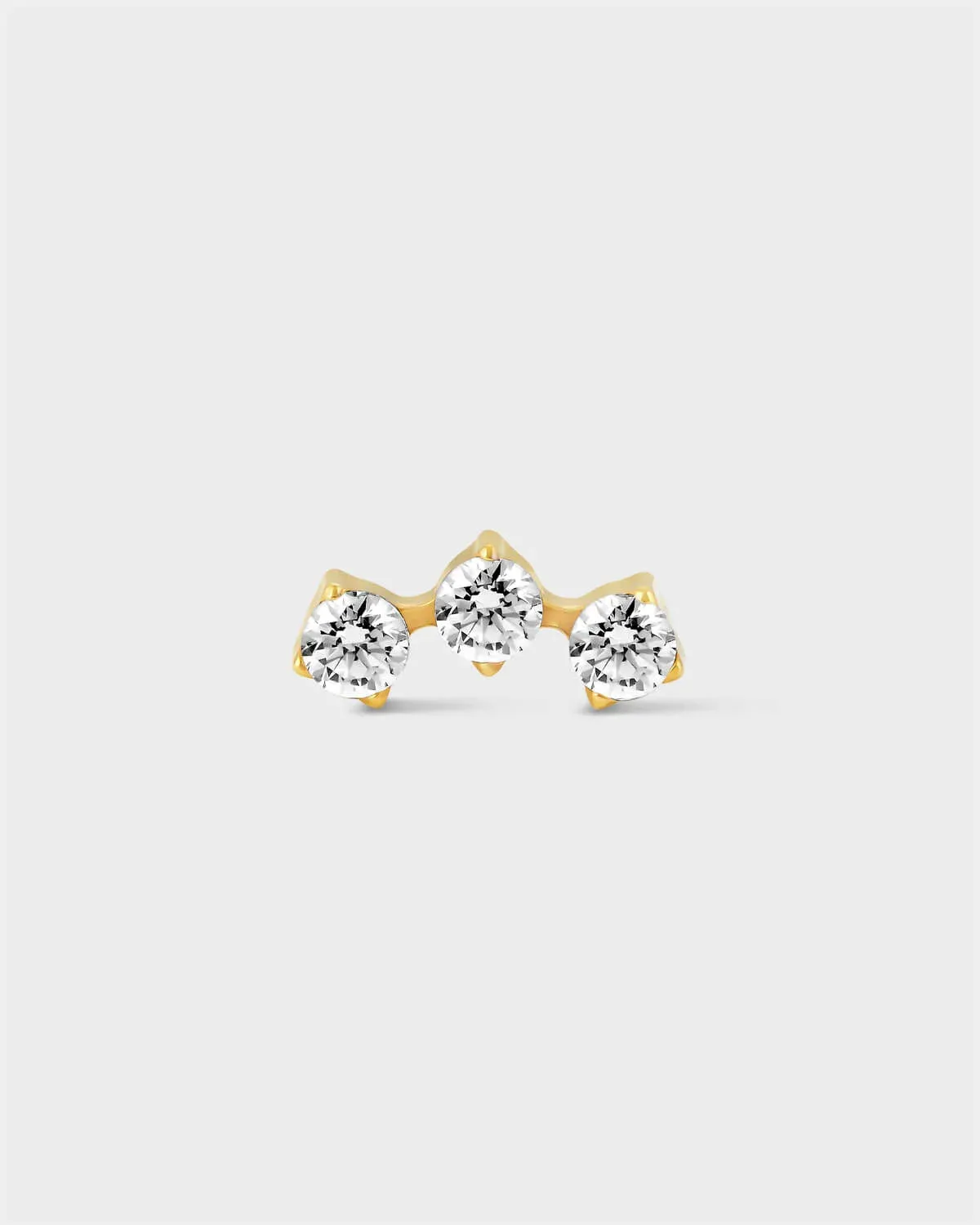 Delicate gold titanium earring with 3 gemstones in an arc formation on a light grey background