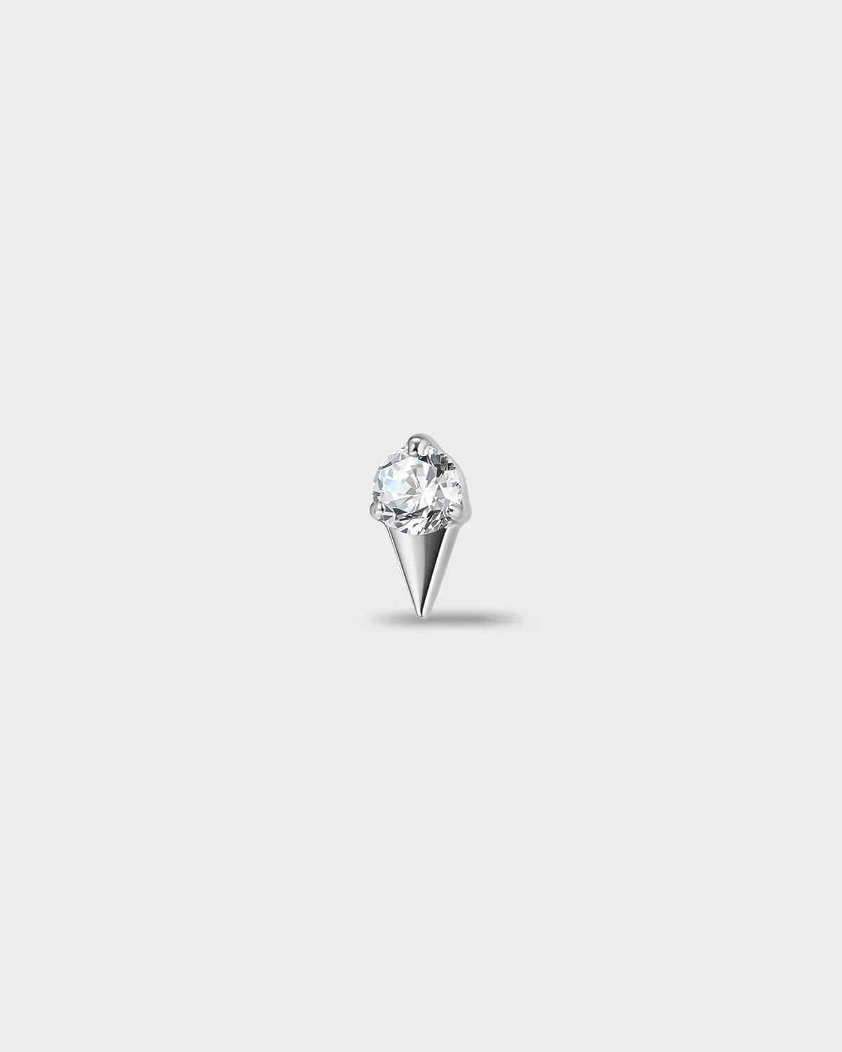 Polished titanium earring with a round-cut clear stone set above a tapered, sculpted base, on a light gray background.