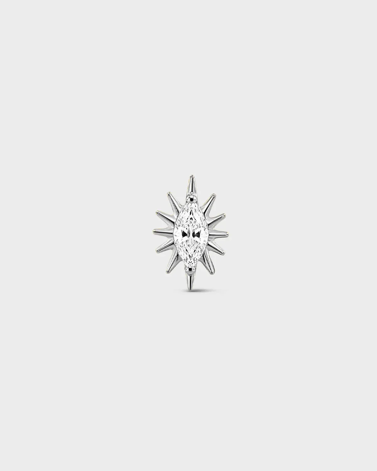 Polished silver titanium threadless end earring with a marquise-cut clear stone set within a sculpted starburst design. On a light grey background.