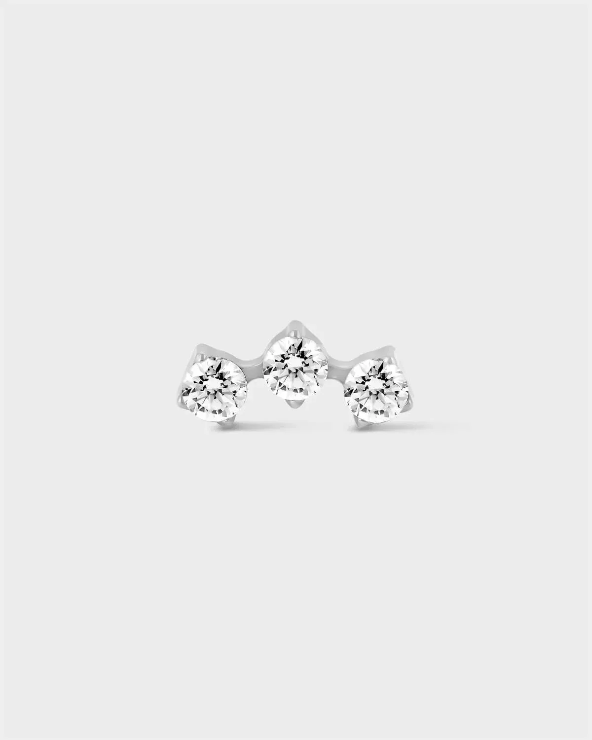 Delicate polished titanium earring with 3 gemstones in an arc formation on a light grey background