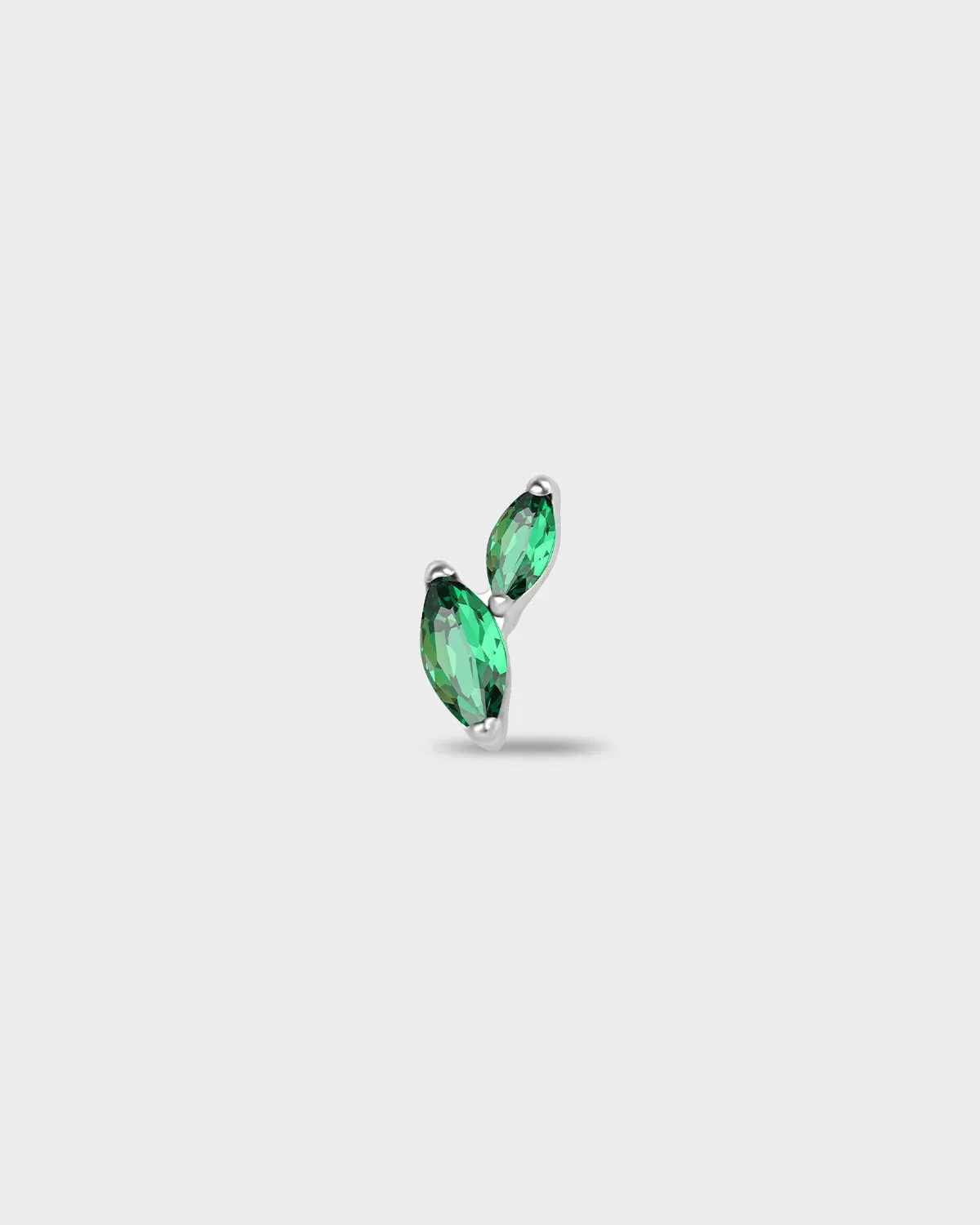 Polished silver titanium earring with two marquise-cut emerald green stones set in a curved vertical arrangement on a light gray background.