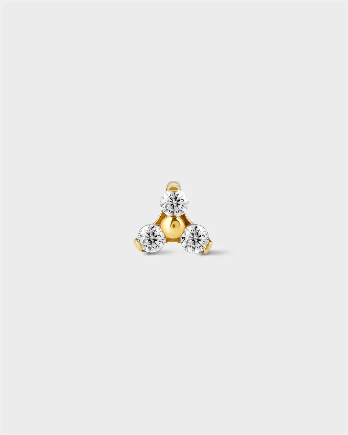 Gold titanium earring with 3 small ems in a triangular formation on a light grey background.