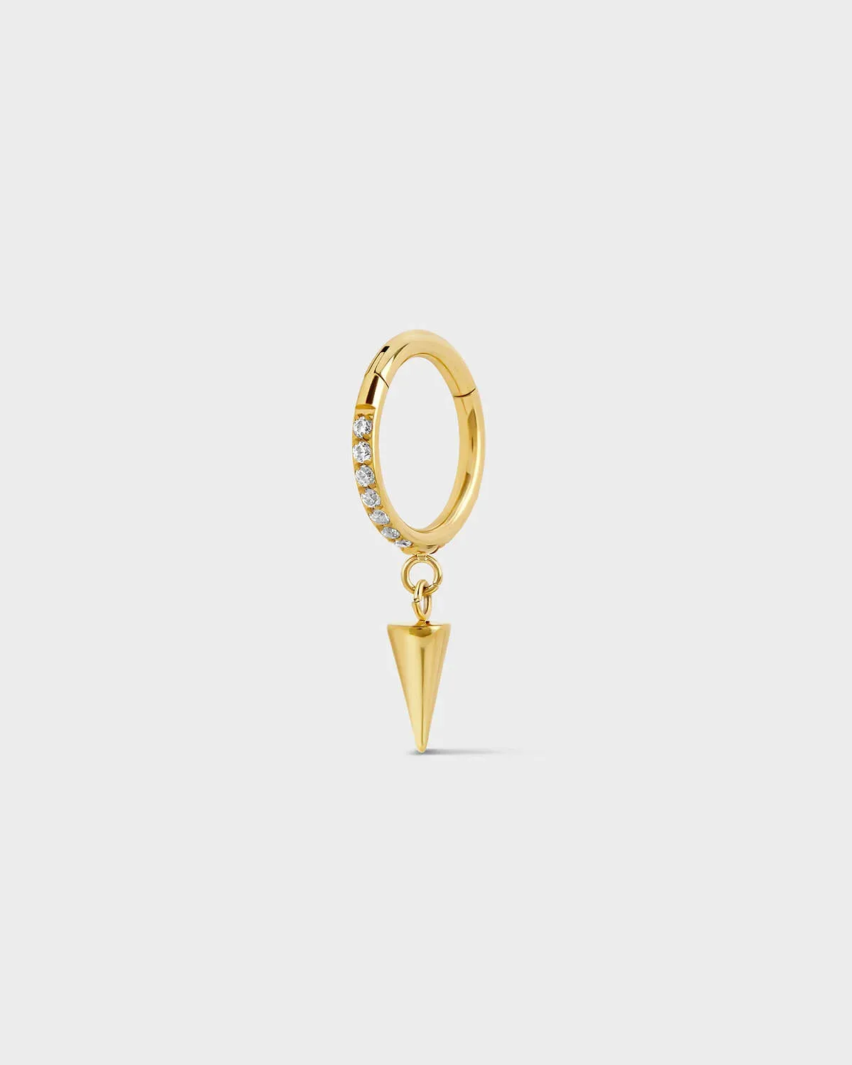 Gold titanium hinged ring with pave gems around the outer edge and a single cone dangle charm sat on a light gray background.