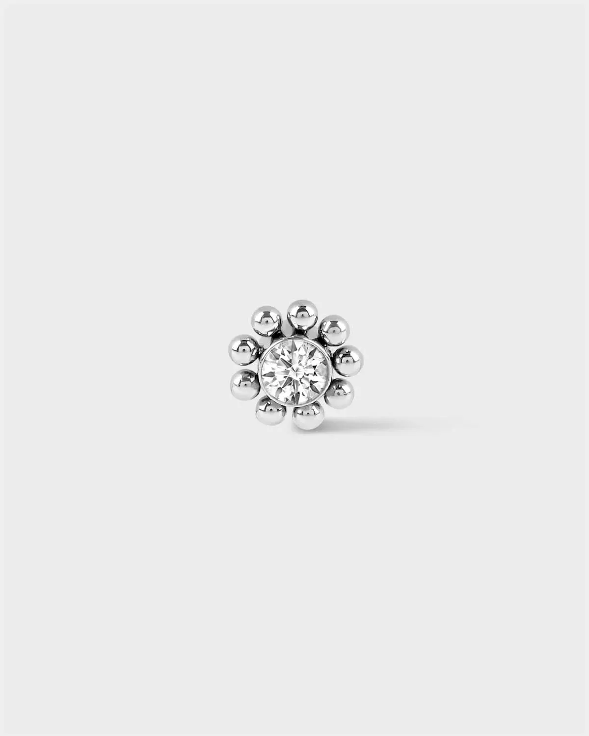 Polished silver titanium Full beaded solitaire earring on light grey background