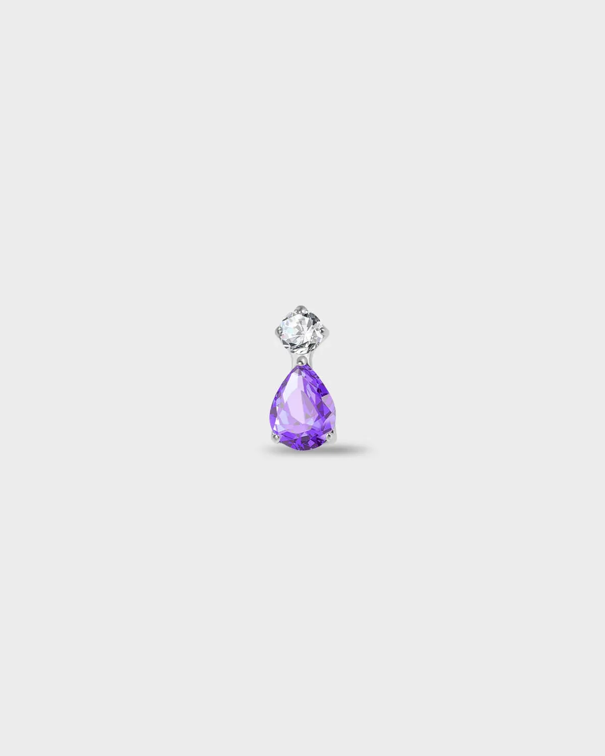 Polished silver titanium earring with a round-cut clear stone set above a pear-cut amethyst purple stone on a light gray background.