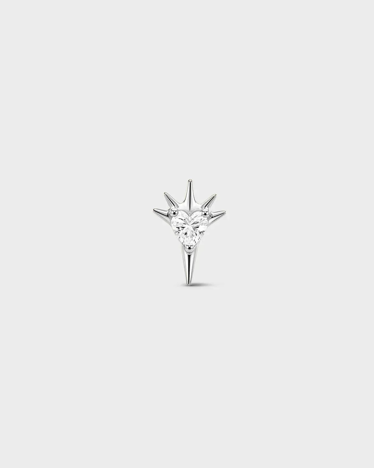 Polished silver titanium threadless end earring with a heart-cut clear stone set within a sculpted starburst design. On a light grey background.