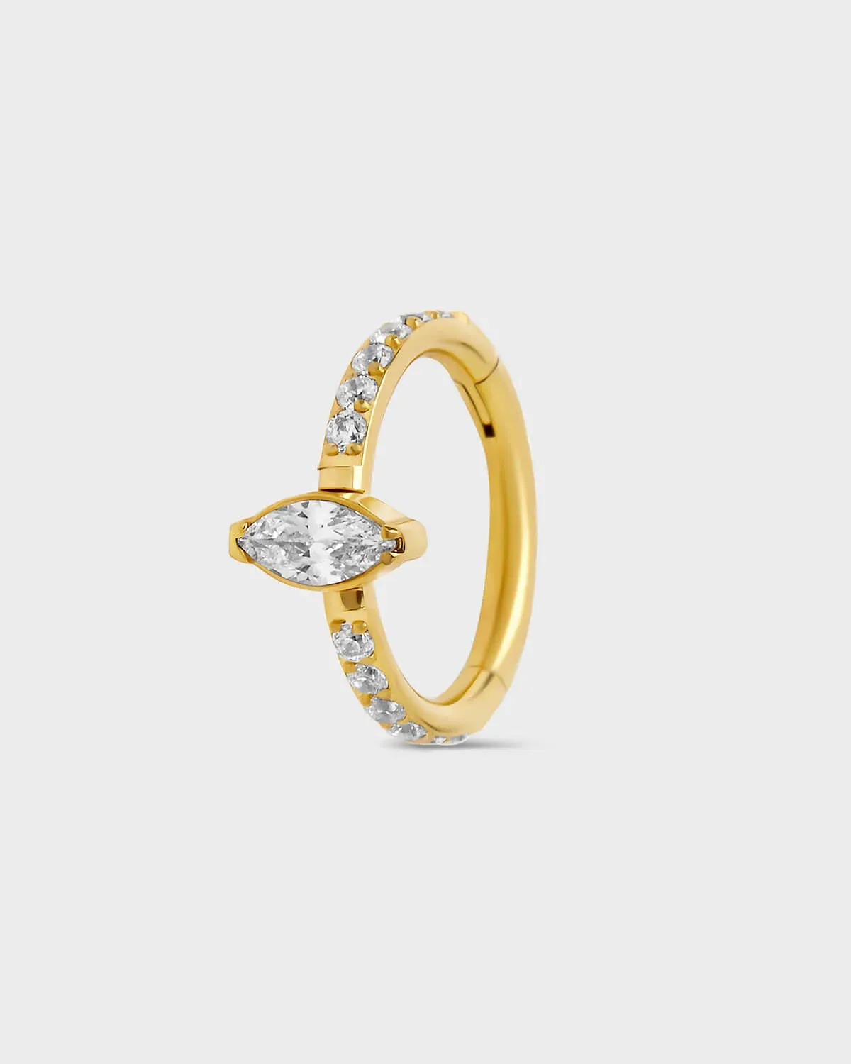 Gold titanium pave hinged ring with central marquise gem sat on a light gray backround.