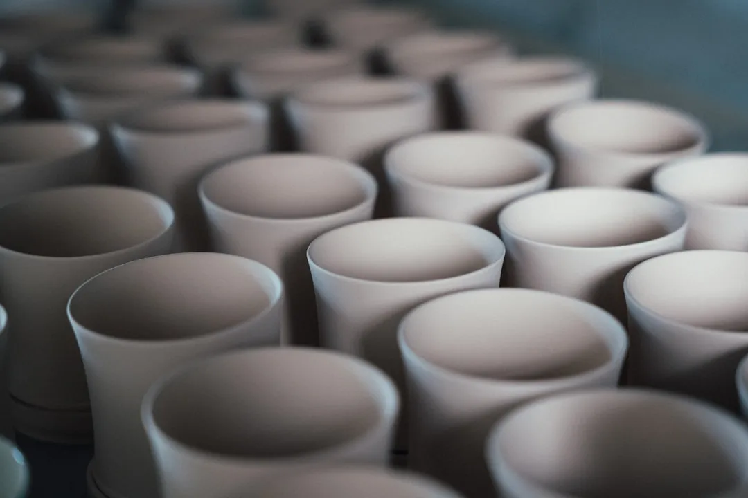 Rows of unglazed ceramic cups in a workshop