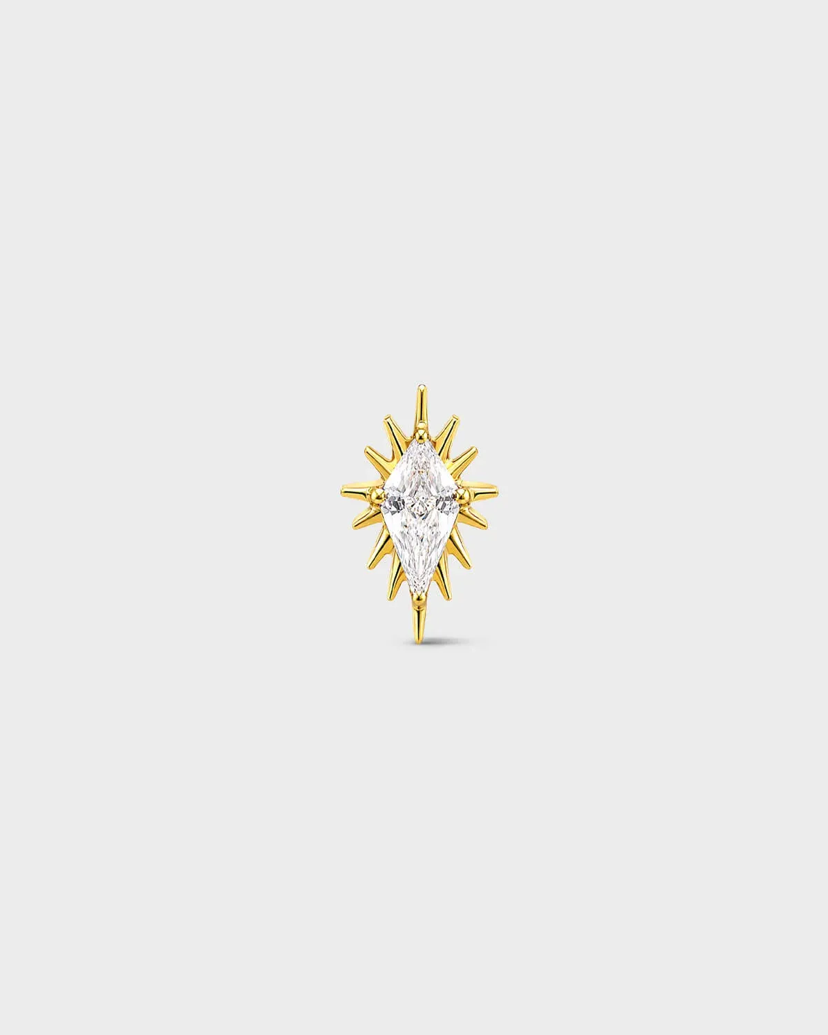 gold titanium threadless end earring with a marquise-cut clear stone set within a sculpted starburst design. On a light grey background.
