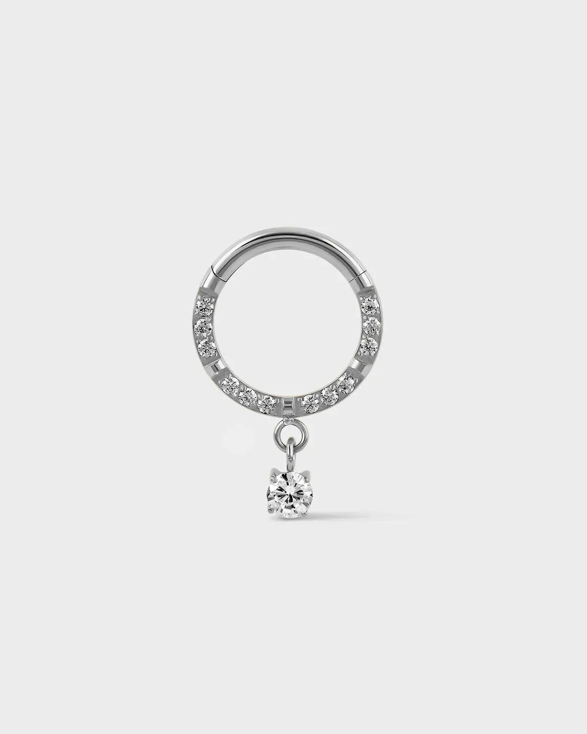 Semi pave hinged polished silver titanium daith septum ring with a solitaire drop charm sat on a light gray background.