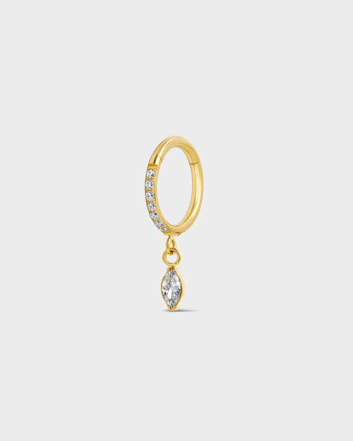 Gold titanium hinged ring with clear pave gemstones around the outer edge and a single dangle marquise charm sat on a light gray background.