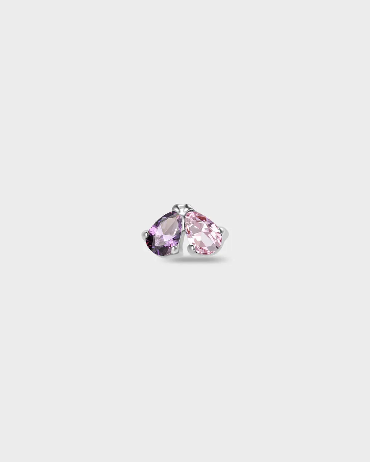 Polished silver titanium earring with two pear-cut stones set side by side, one purple and one pale pink on a light gray background.