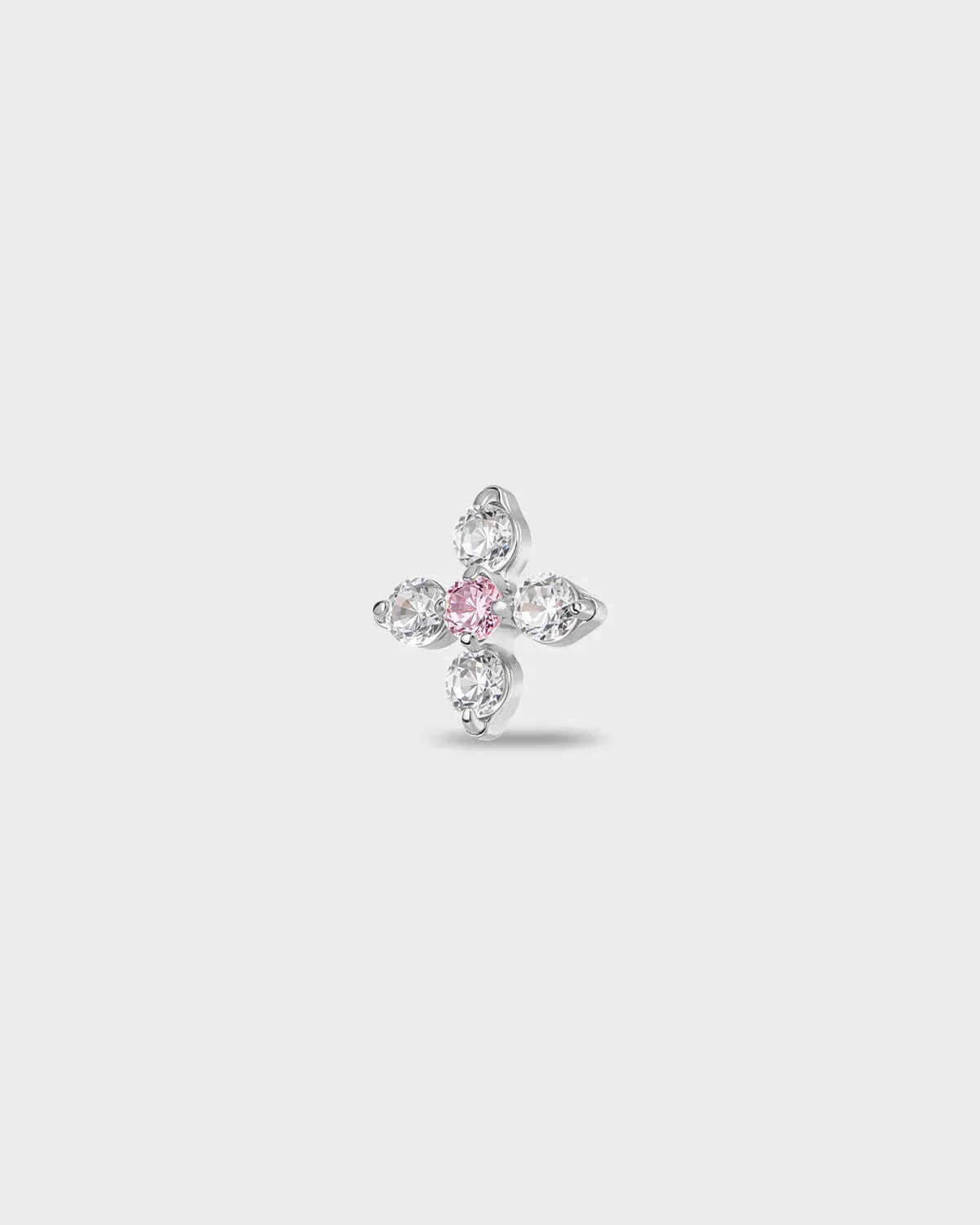 Polished titanium earring with four round-cut clear stones set around a single round-cut pale pink stone, on a light gray background.