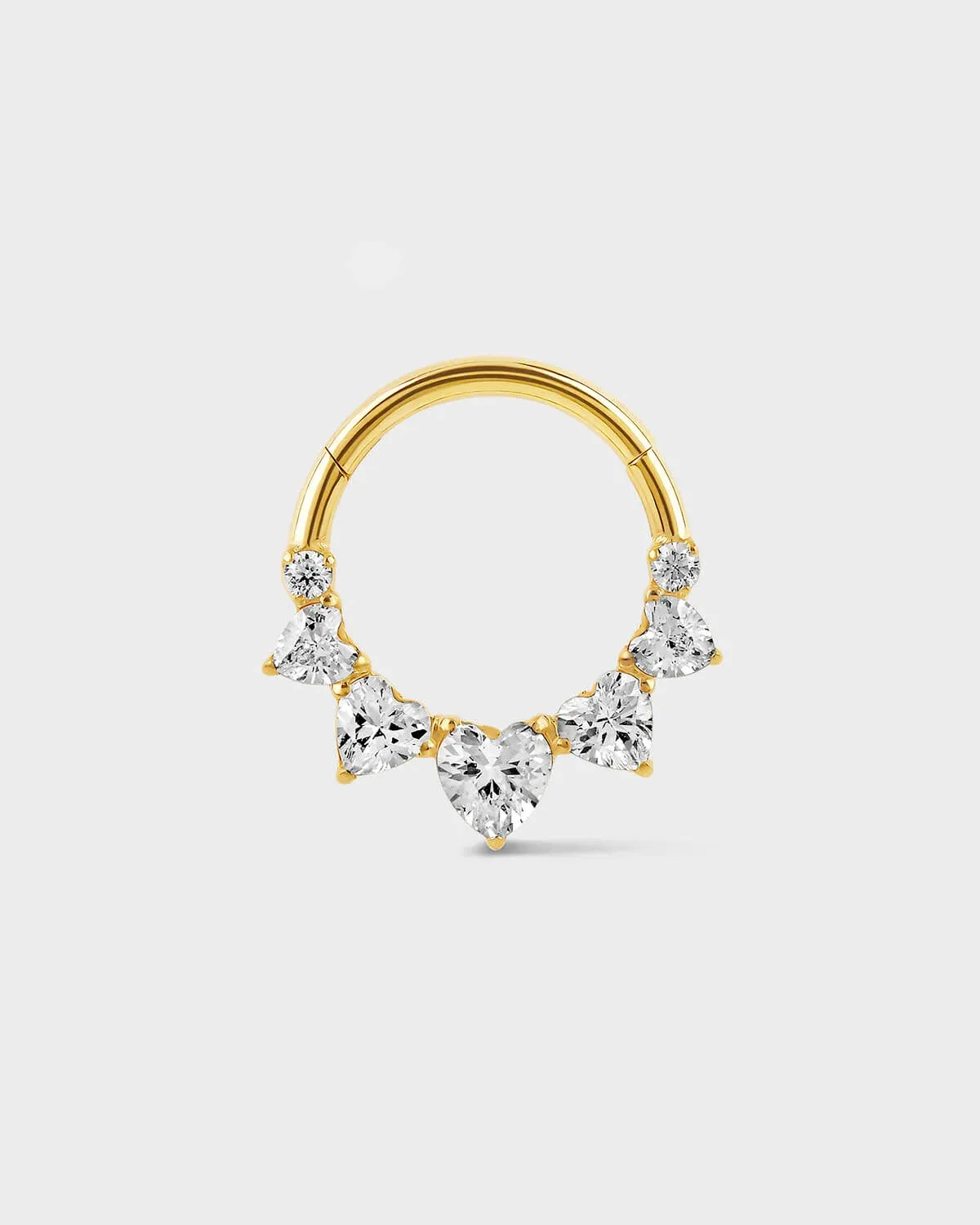 Gold titanium Daith or septum ring with five graduated heart shape gems and two smaller round gem sat on a light gray background