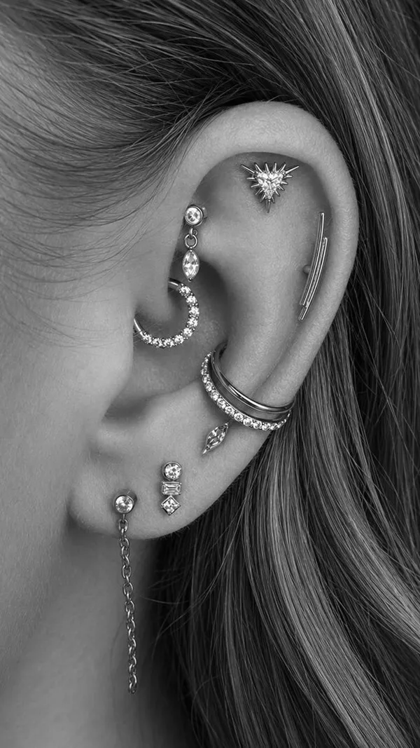 Close-up of a curated ear with multiple piercings and jewellery